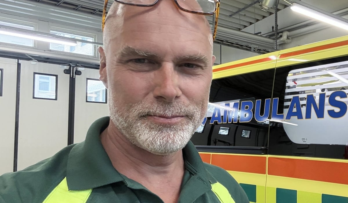 En man som står framför en ambulans.